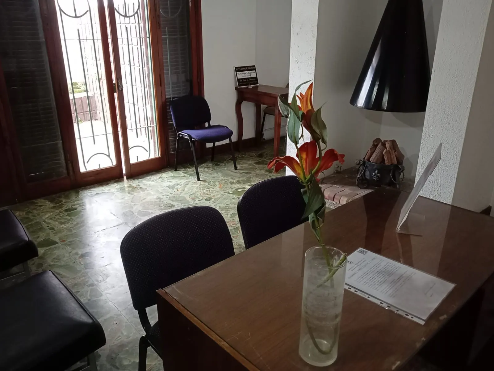 Recepción del estudio con escritorio de madera y ventanal